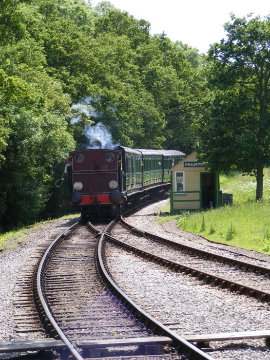 a train engine pulling its train cars down the railroad tracks