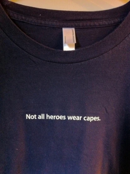 an unisex t - shirt that says, not all hero's wear capes