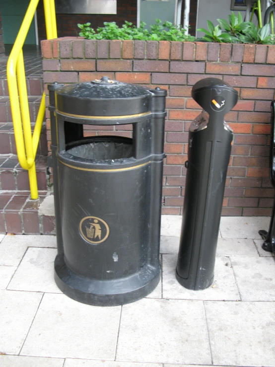 two trash can next to a brick wall