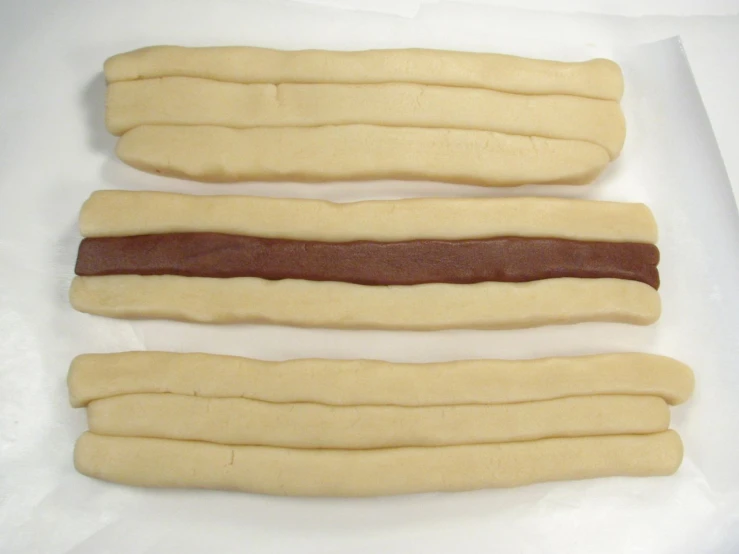 three long  dogs in some thin uncooked buns
