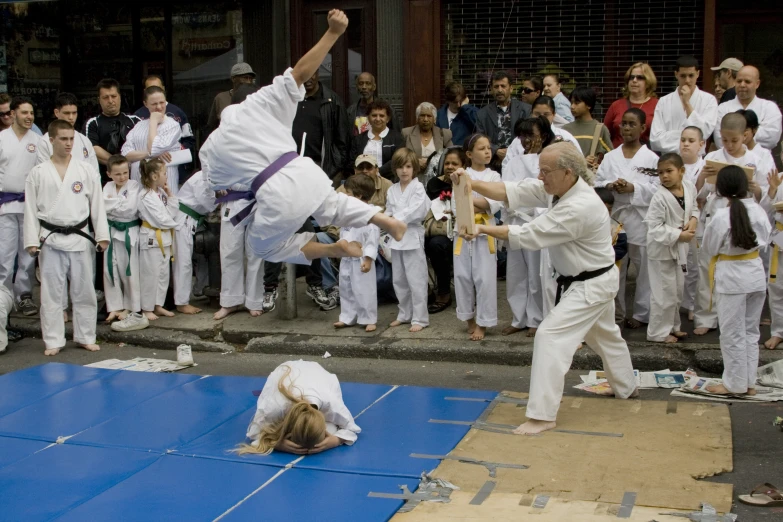 two people practicing karate moves while an audience watches