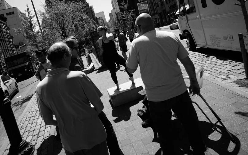 a man walks with his suitcase and others on the sidewalk