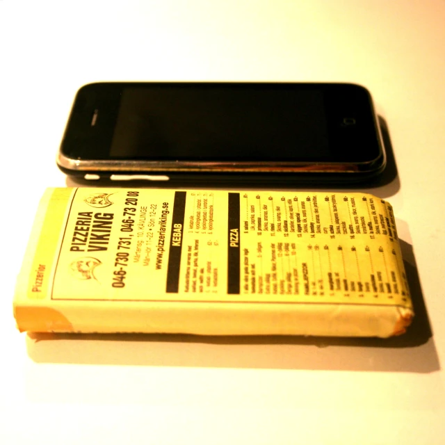 a book sitting on top of a white table next to an iphone