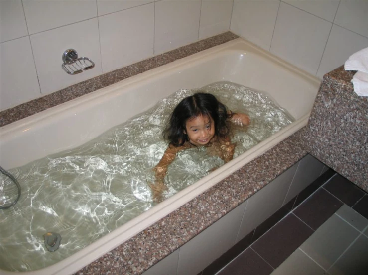  playing in large bathtub in bathroom