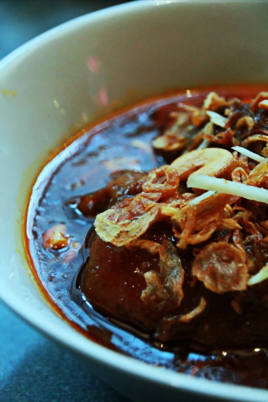 a close up view of a food dish with meat, onions and tomato sauce