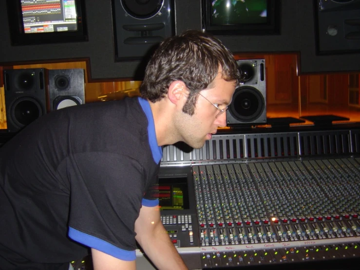 a man working in an audio studio next to sound mixers