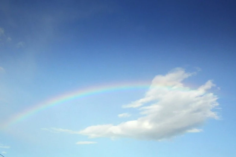 a rainbow is seen with blue sky in the background