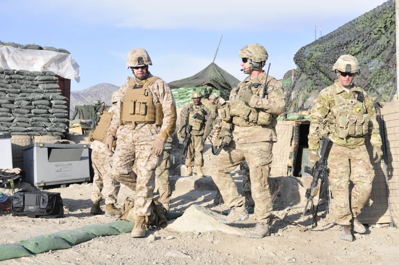 several soldiers stand and talk in the dirt