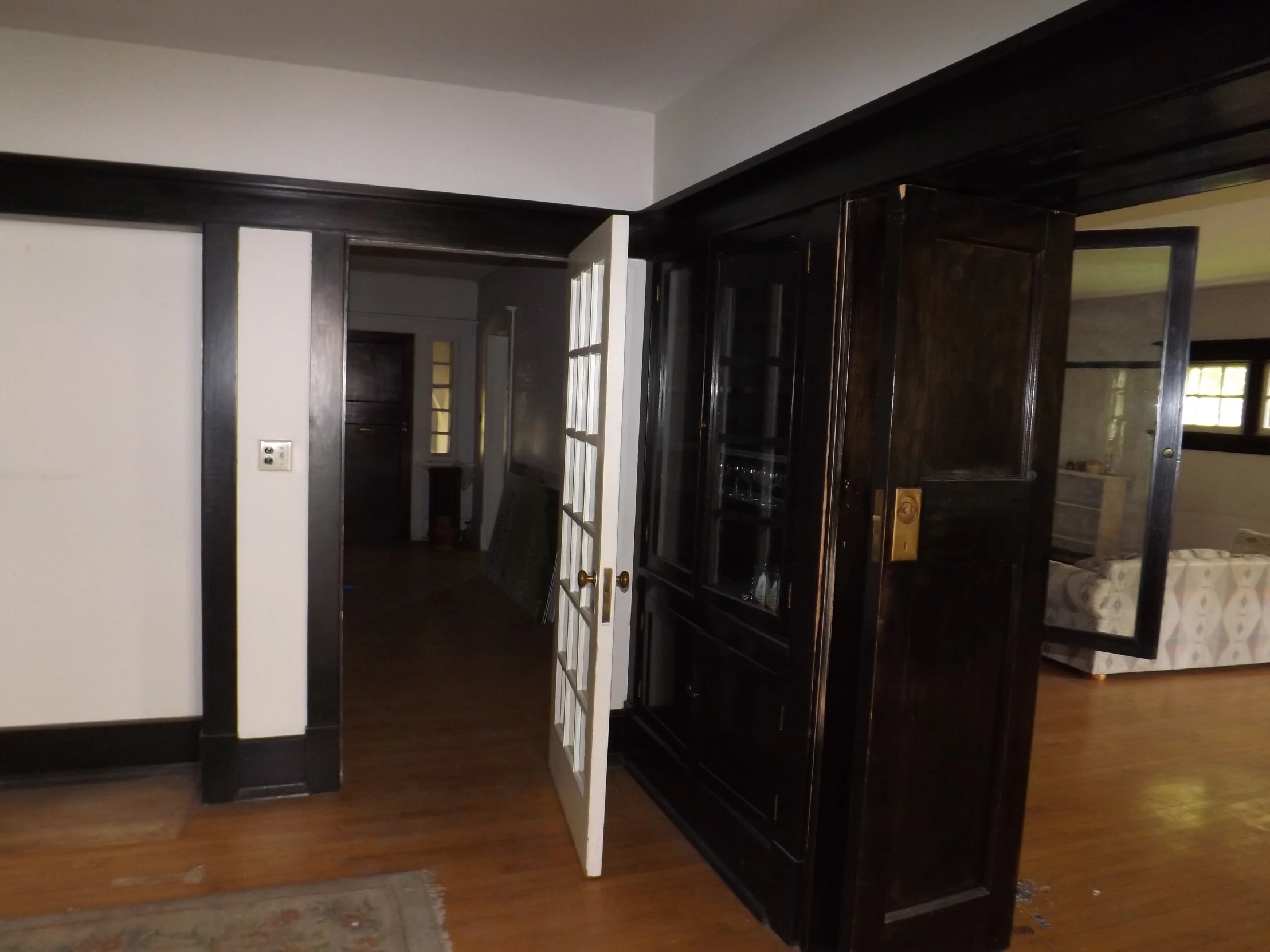 two black closets side by side with mirrors on the wall