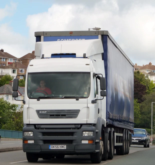 a large semi is moving on a residential road