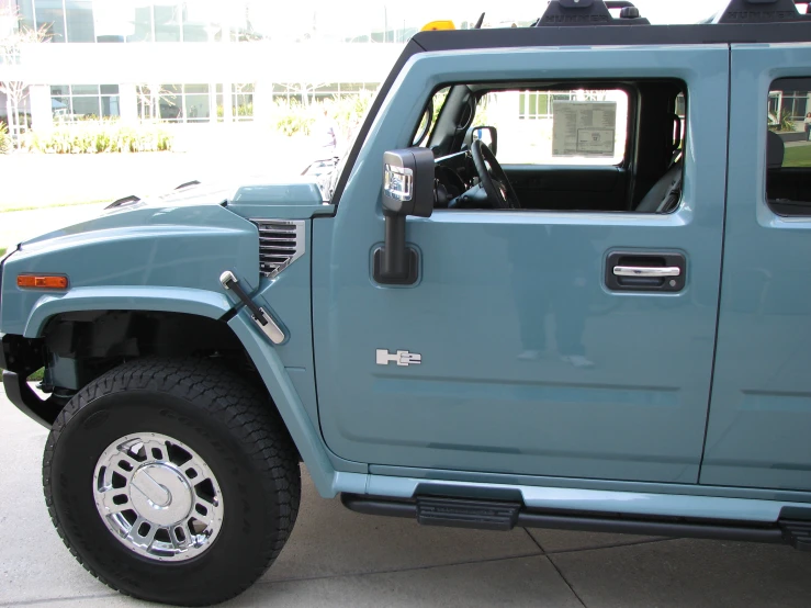 a light blue pickup truck has a flat tire and a front tire drive