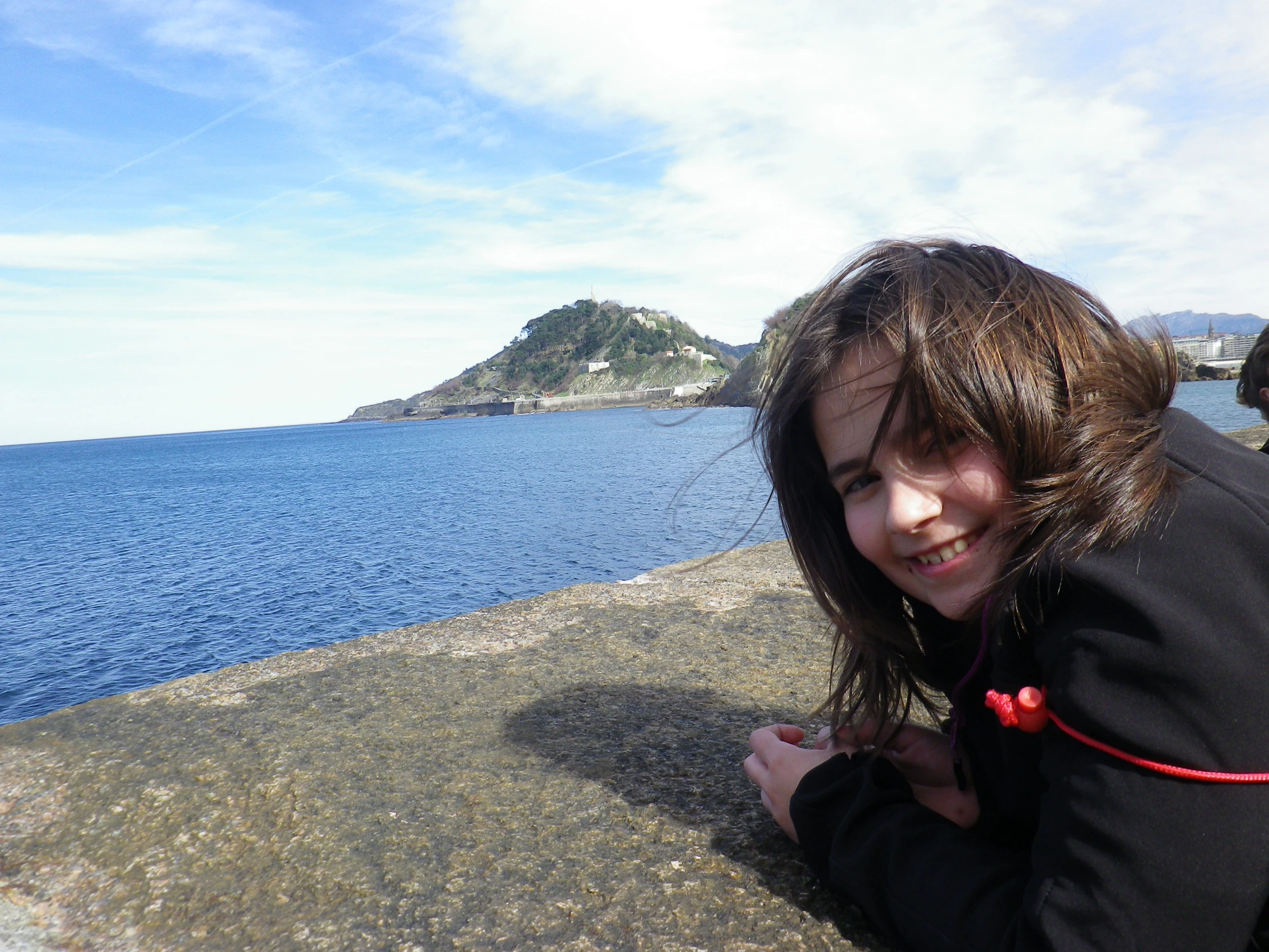 a girl is posing in front of the water