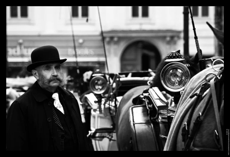 a man standing next to a horse and carriage with an old style helmet on