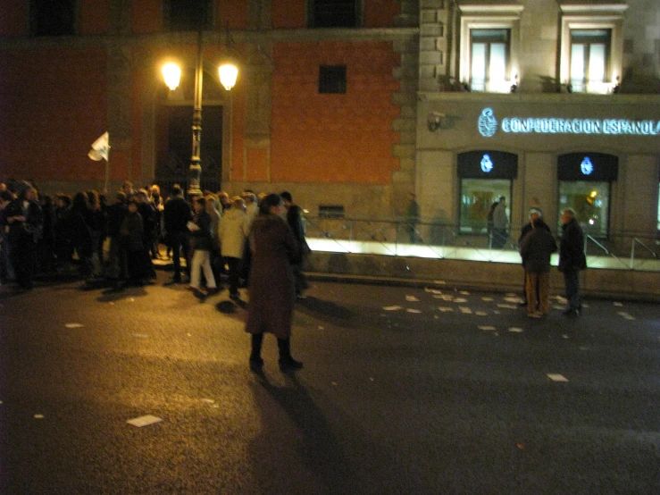 people gathered outside of a building as the street is deserted