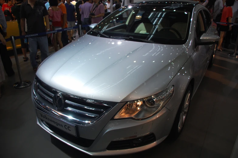 silver car with bright lights on display at a convention