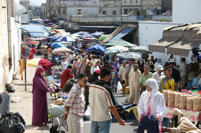 the crowd is shopping outside on the sidewalk