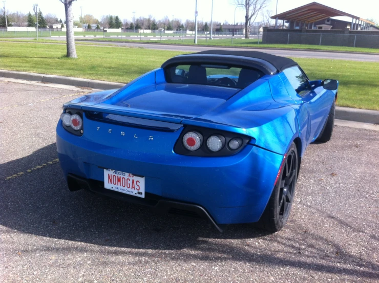 the back end of a blue sports car in a parking lot