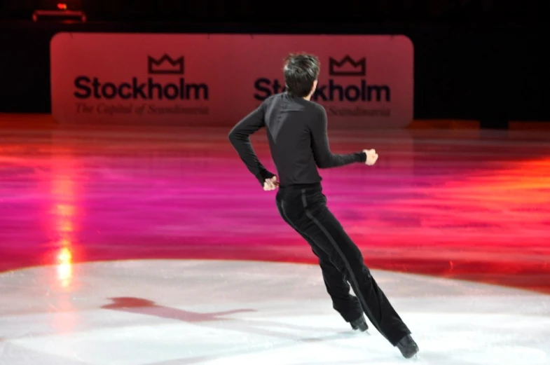 a man in black skating on the ice