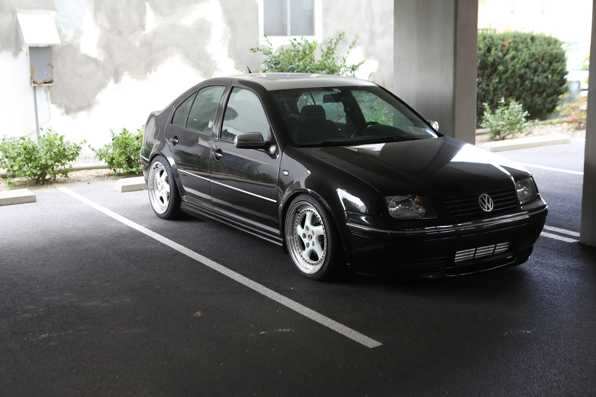 a black car is parked in a parking lot