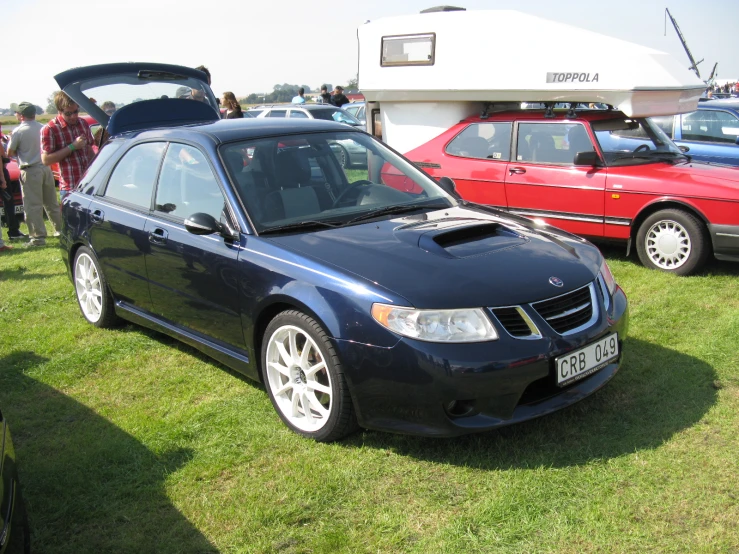 several cars that are sitting on some grass