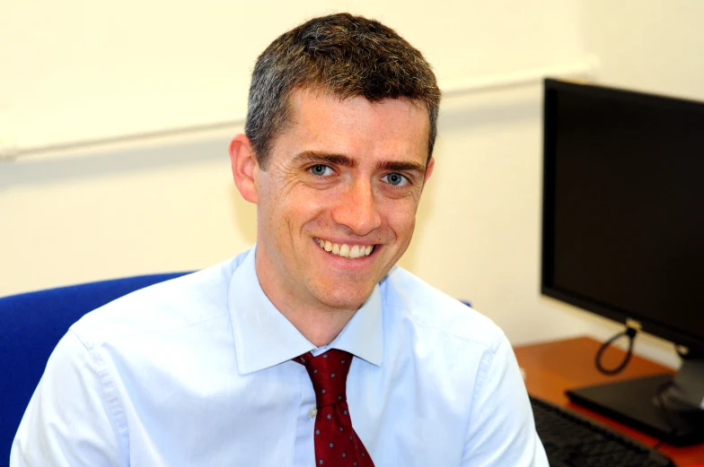 man wearing red tie and smiling for the camera