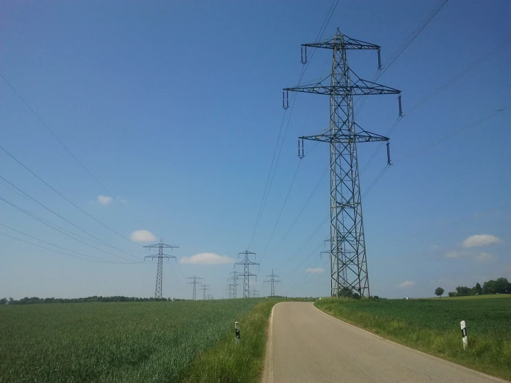 three power lines and two people are standing on the road