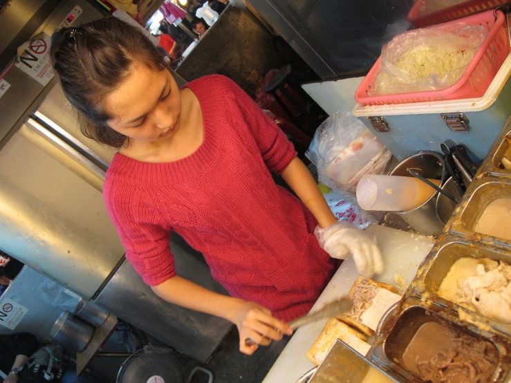 woman in red shirt at counter making chocolate dessert