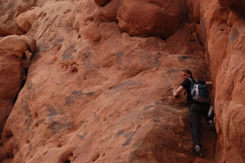 a man standing on the side of a canyon while talking on a cell phone