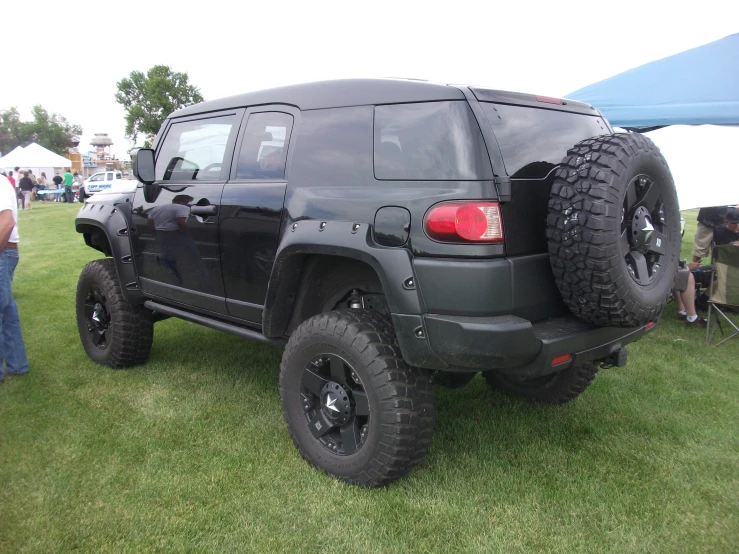 a black jeep with black tires and a large rear tire