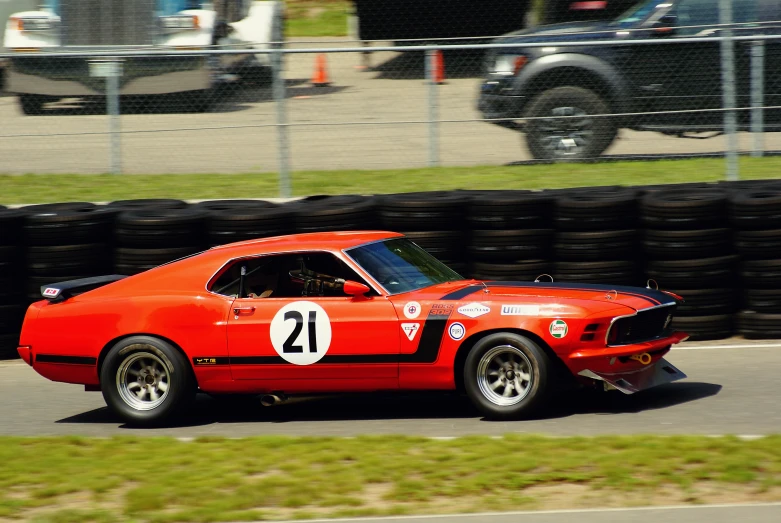 an older red car driving around a track