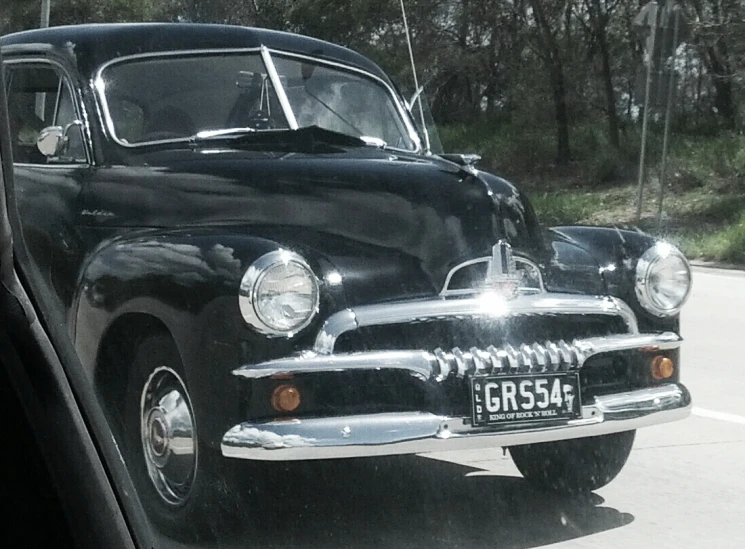 an old black car is sitting outside on the street