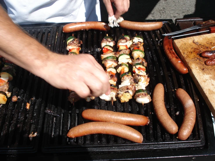 a person cooking on a grill next to  dogs