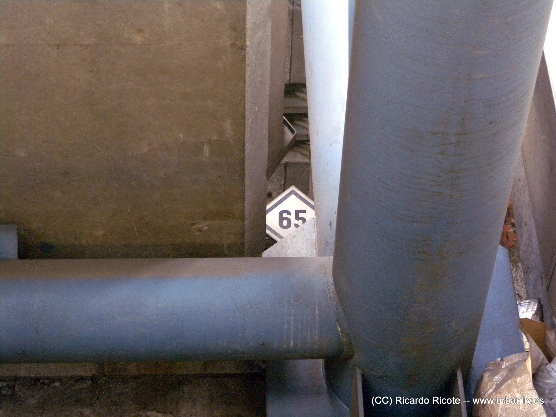 a gray pipe with an analog sign is on the ground