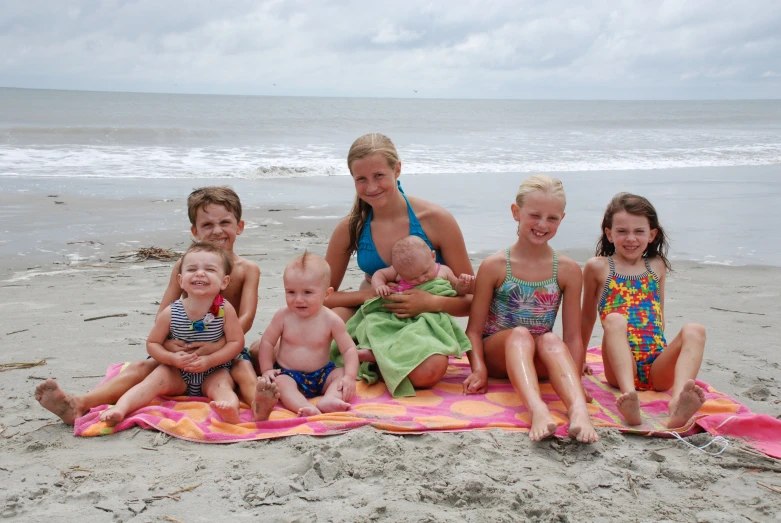 a group of s sitting on a beach