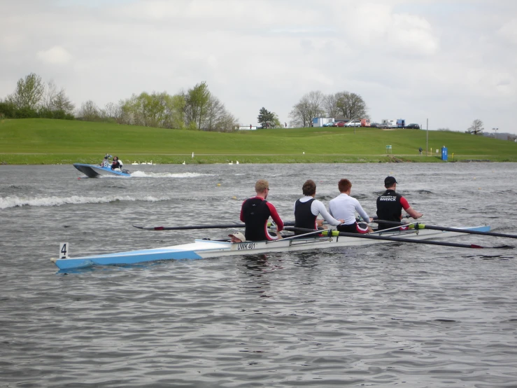 four rowers in canoe on a very choppy body of water