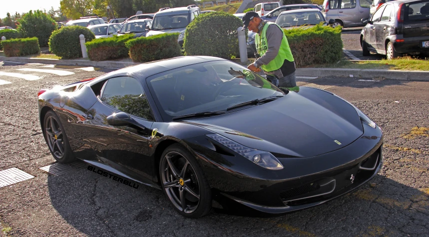 a man standing next to a black sports car