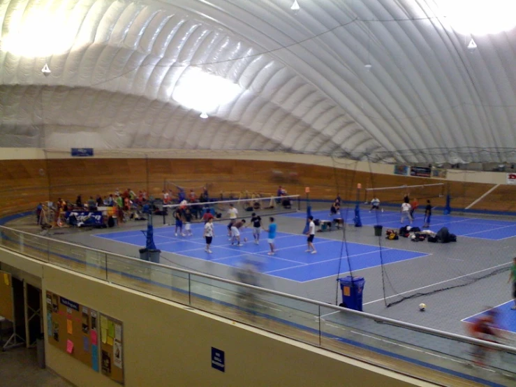 the indoor tennis court is full of many people