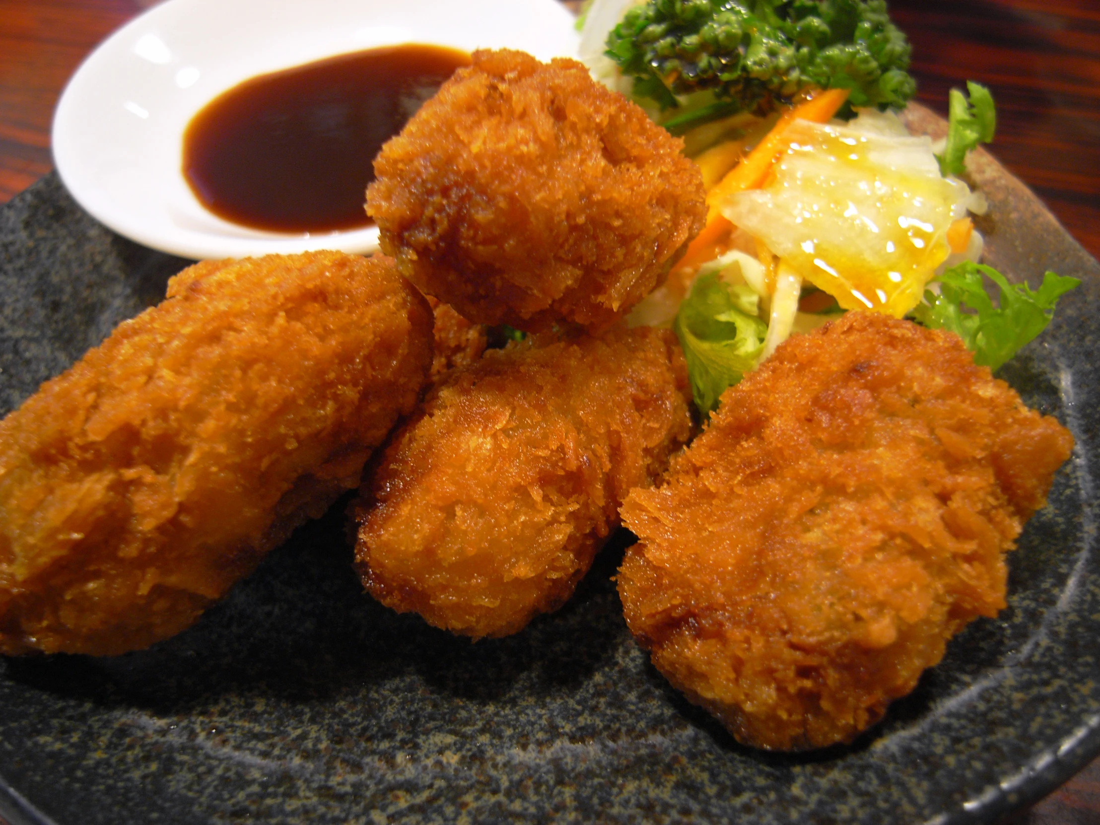 fried chicken and salad served on black plate