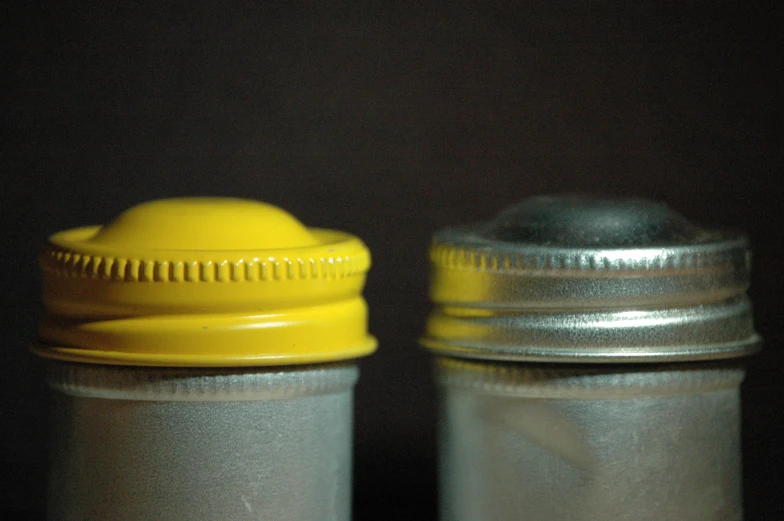 two tin cans sitting side by side next to each other