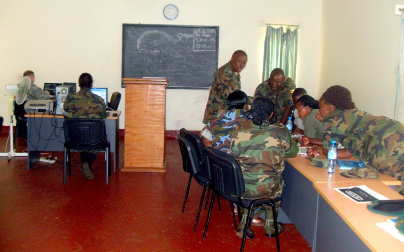army men sitting at desks in a classroom