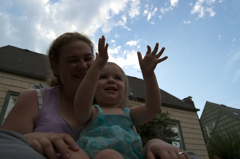 a woman holds a small child on her shoulder