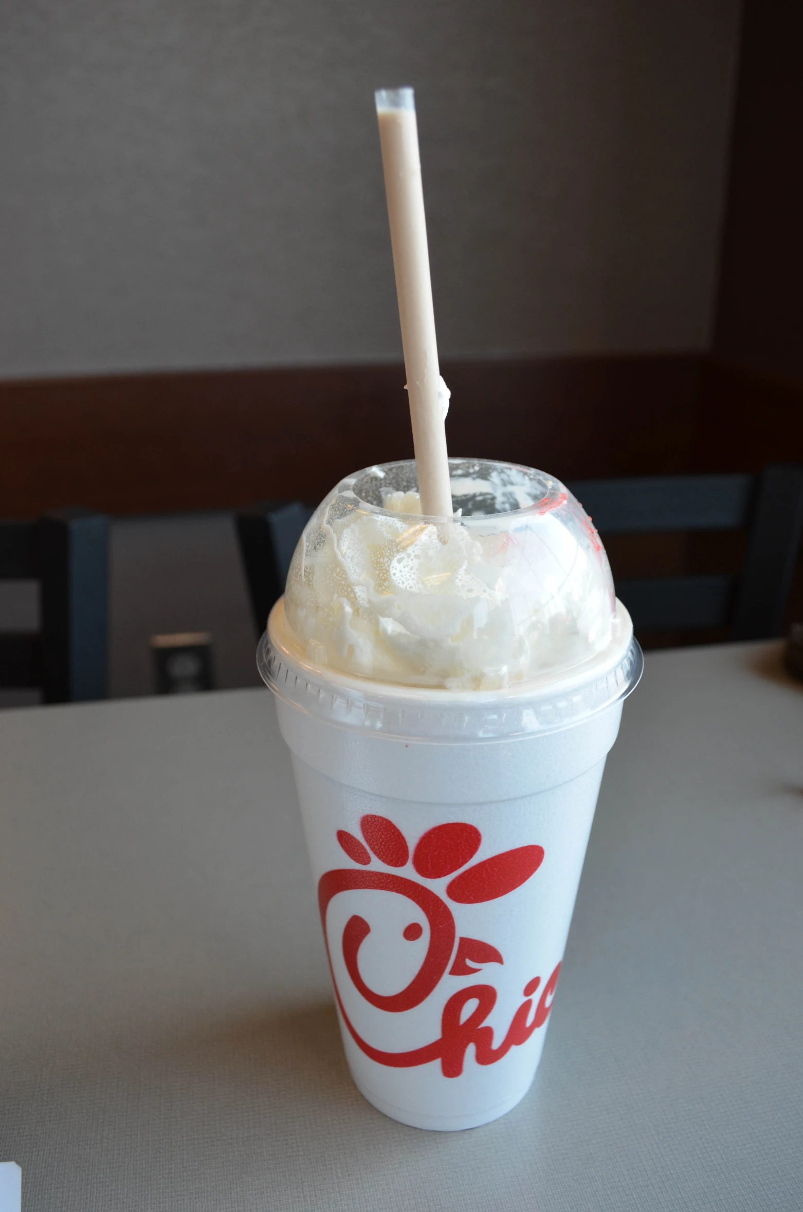 an iced cup filled with whipped cream and a straw