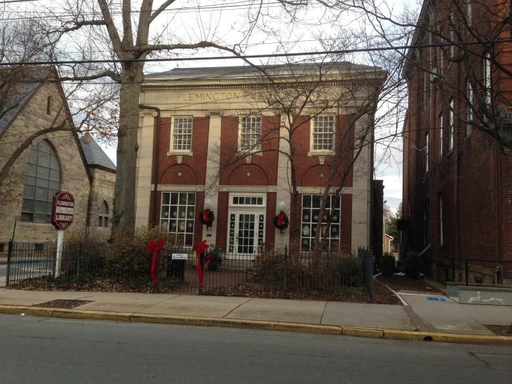 the street view shows a very old, red brick building with a fence