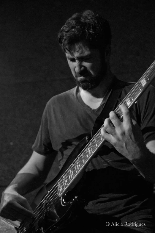 a man playing guitar and looking at the camera