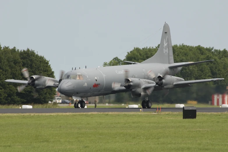 a military plane sitting on a runway in a field