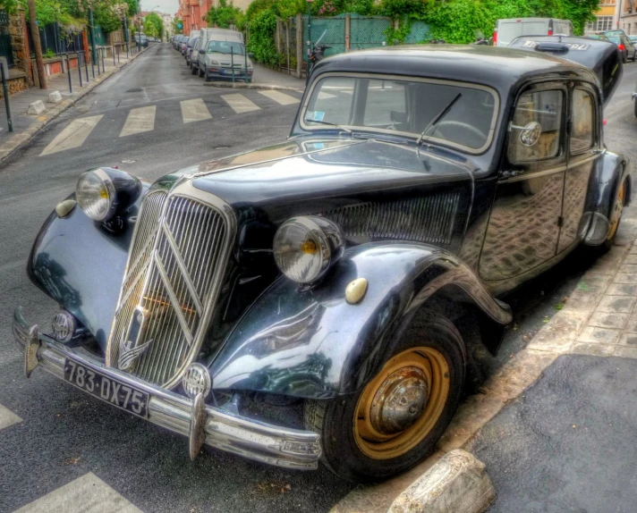 a black old fashioned car is parked on the side of the road