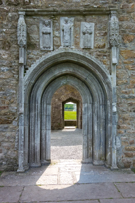 a doorway with statues at the entrance to a castle