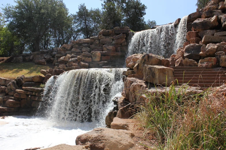 a water fall with a bridge next to it