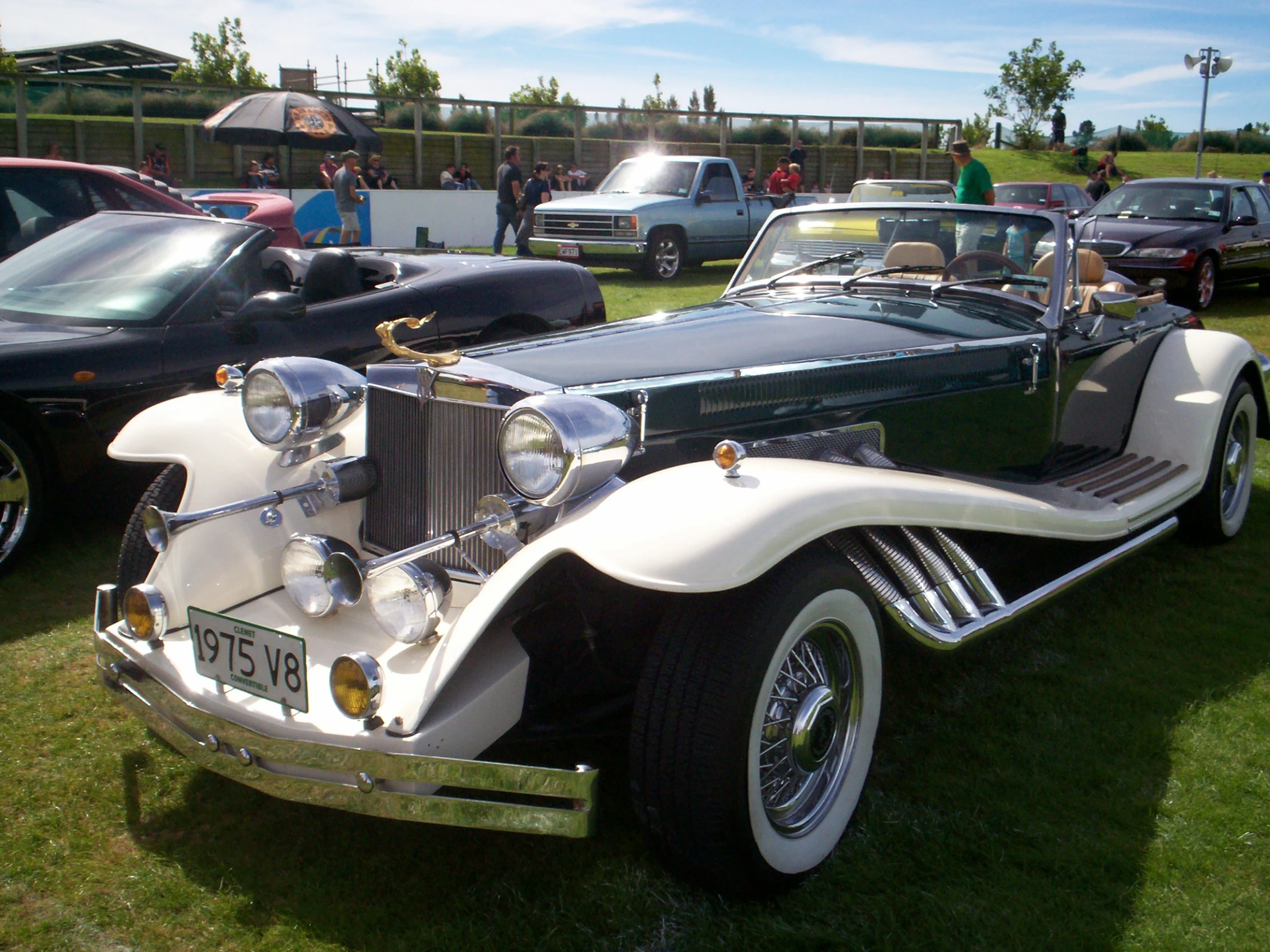 an old white vintage car parked near other antique cars