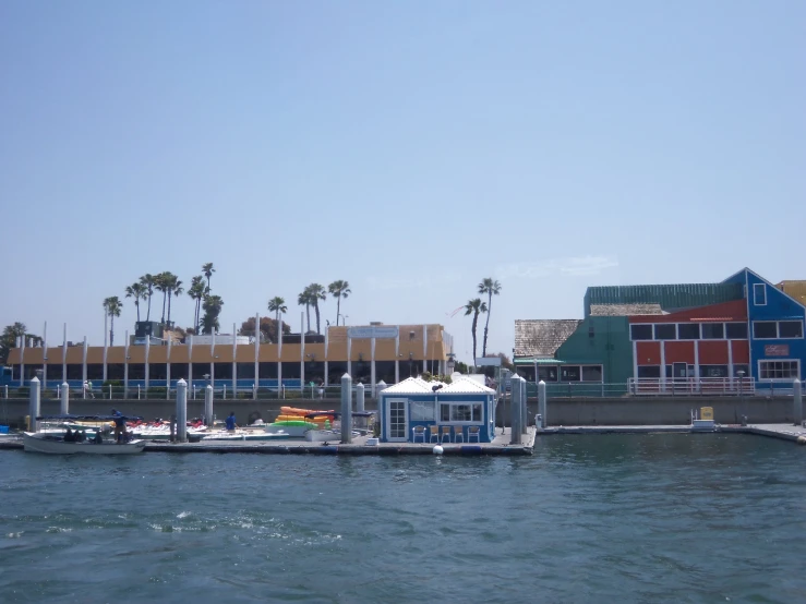 a body of water with a boat going by it and several houses and palm trees